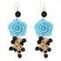 Pendientes compuestos por una rosa azul de resina y cuentas de color negro. Gancho dorado que no pierde su color de Marardi