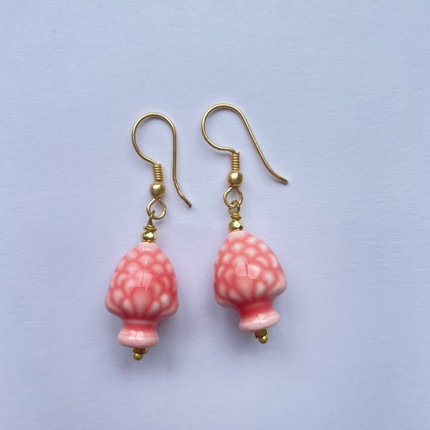 Pendientes cortos de cerámica siciliana hechos y pintados a mano, son unas piñas rosas de Marardi