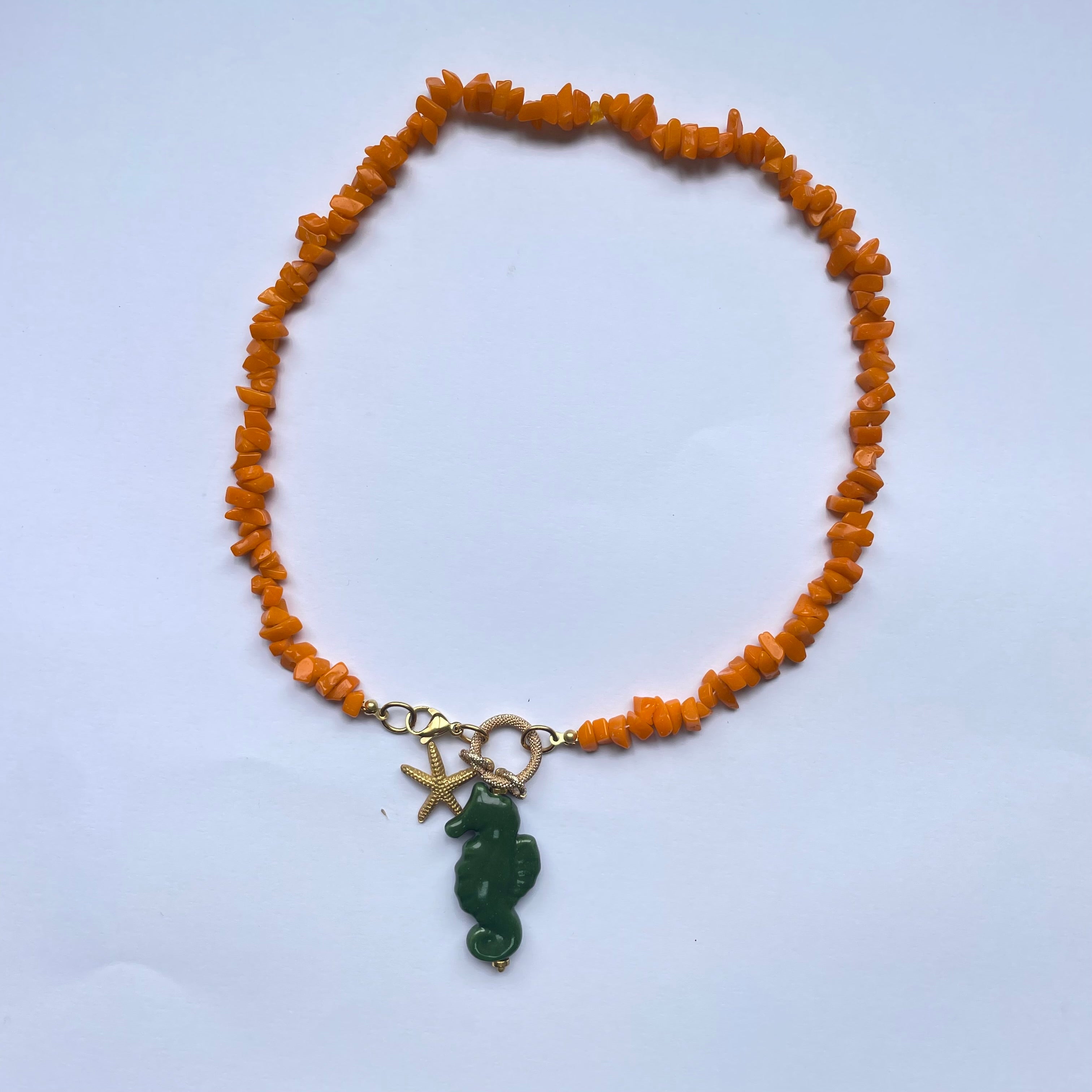 Collar corto de piedras naranjas y un caballito de mar verde de cerámica adornado con perla natural y estrella dorada Marardi