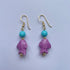 Pendientes cortos con pez de cerámica siciliana lila adornado con una cuenta turquesa, el gancho es dorado y son de Marardi.