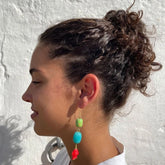 Pendientes largos con una piedra verde y otra turquesa y con un pececito rojo de cerámica y el gancho es de latón de Marardi