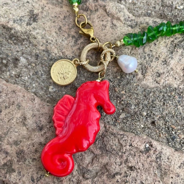 Collar corto de piedras verde y colgante de cerámica que es un caballito de mar rojo con una perla natural y estrella marardi
