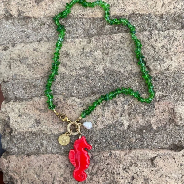 Collar corto de piedras verde y colgante de cerámica que es un caballito de mar rojo con una perla natural y estrella marardi
